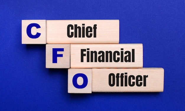 On a bright blue background, light wooden blocks and cubes with the text CFO Chief Financial Officer