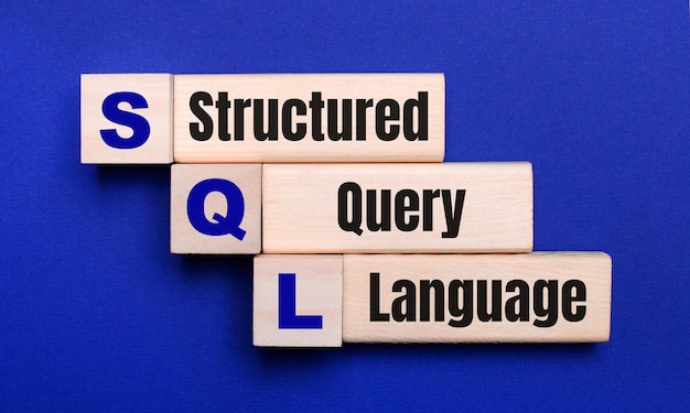 On a bright blue background, light wooden blocks and cubes with the text SQL Structured Query Language