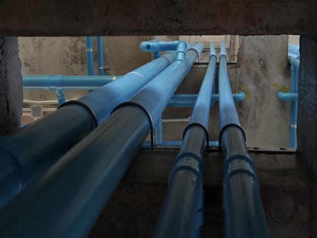 Photo a bright blue pipes attached to a solid concrete wall