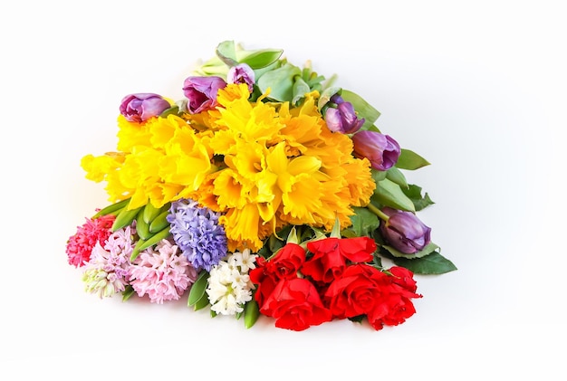 Bright bouquet of spring flowers on white background. Narcisus, roses and hyacinth.