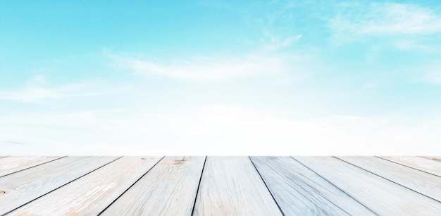 Bright cean wooden desk on summer sun with clouds in background for product presentation