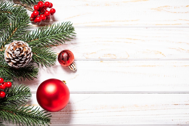 Bright Christmas banner with fir tree branches and red balls on white rustic background