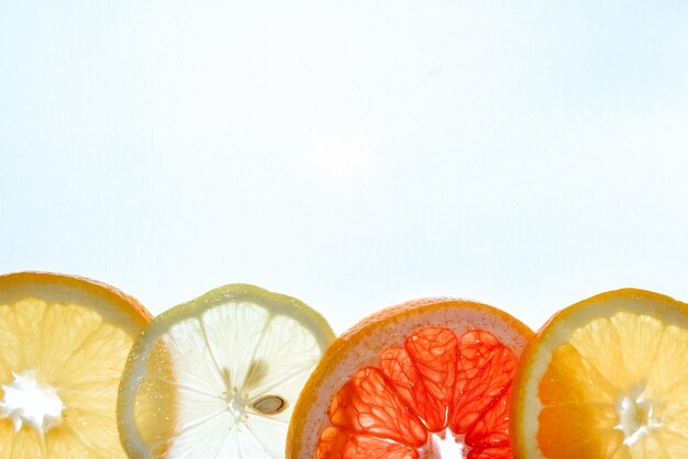 Photo bright citrus lemon, orange and grapefruit slices. juicy transparent fruit on white. copy space