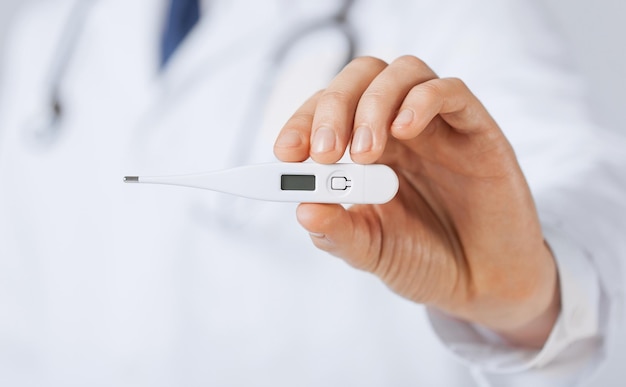 bright close up of male doctor with thermometer