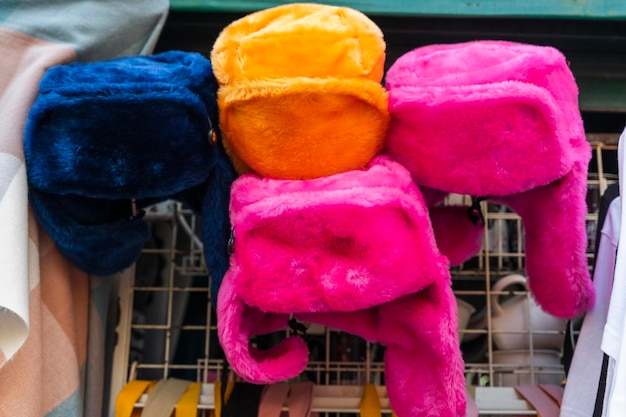 Bright colored fur hats with earflaps on the counter of street vendor