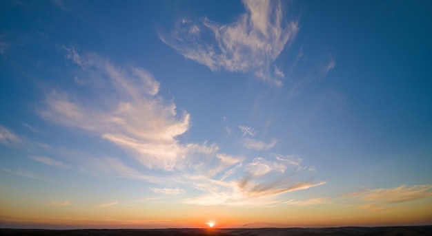 Bright colorful sunset sky with rays of setting sun and vivid dark clouds