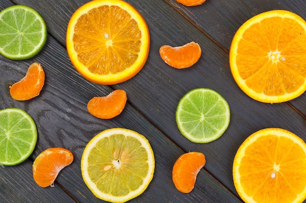 Bright composition of citrus fruits on black wooden table