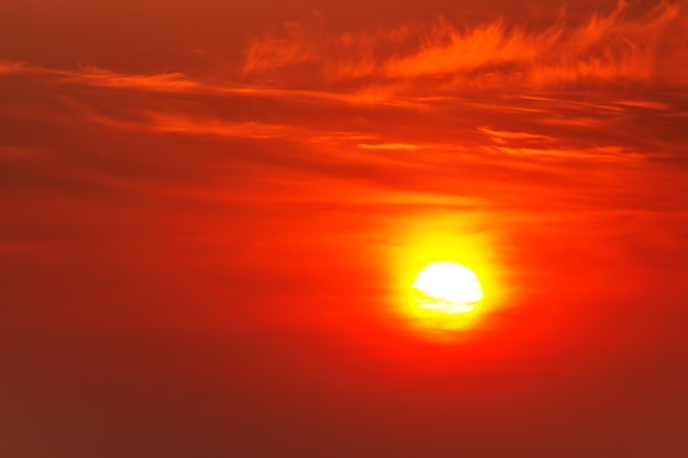 Bright crimson sun on a background of sunset or dawn