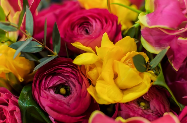 Bright festive bouquet of pink and yellow flowers. Beautiful multicolored bouquet with pink roses.