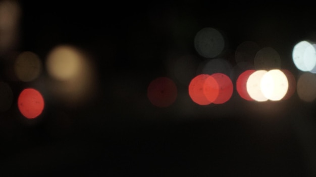 Bright glowing lights of district in megapolis under dusk sky in evening on blurred background