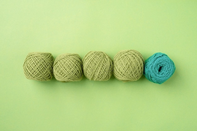 Bright green yarn wool in a raw on bright background top view flat lay