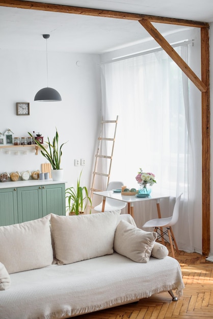 Bright kitchen interior with large windows Kitchen studio White table parquet floor High heels Beams in the interior