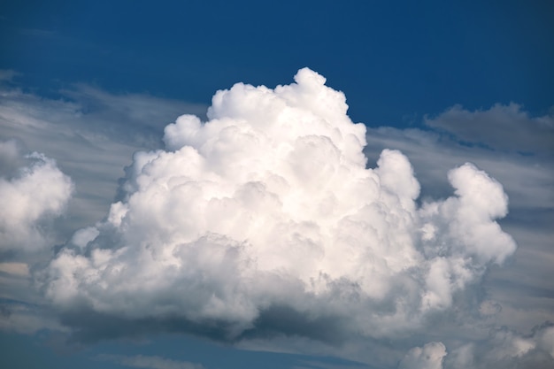 Bright landscape of white puffy cumulus clouds on blue clear sky.