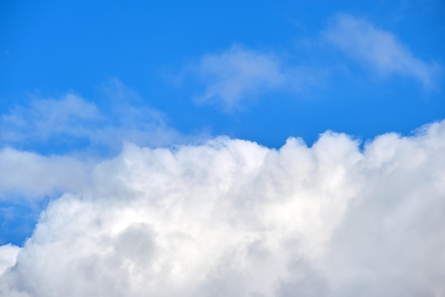 Bright landscape of white puffy cumulus clouds on blue clear sky