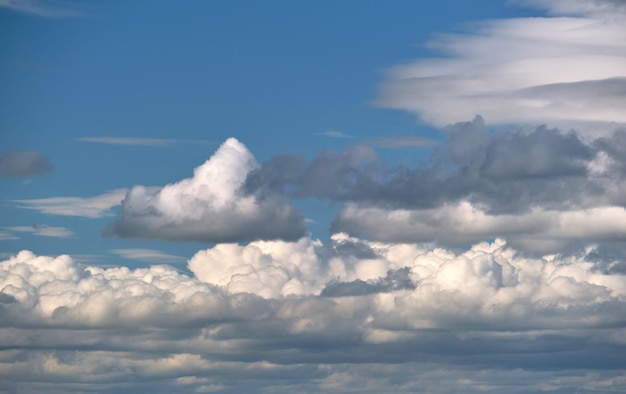 Bright landscape of white puffy cumulus clouds on blue clear sky