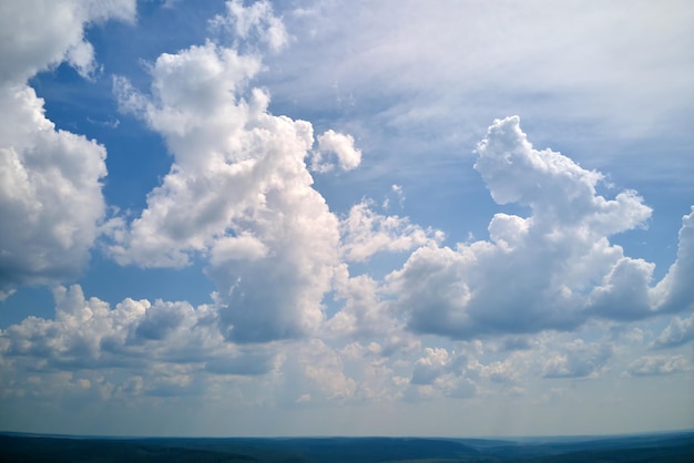 Bright landscape of white puffy cumulus clouds on blue clear sky