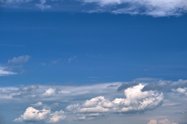 Bright landscape of white puffy cumulus clouds on blue clear sky