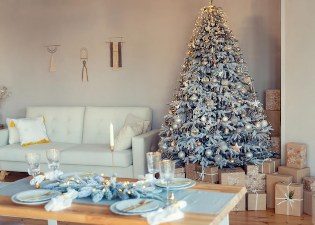 Bright living room decorated with new year decor christmas tree with gold and silver decorations and