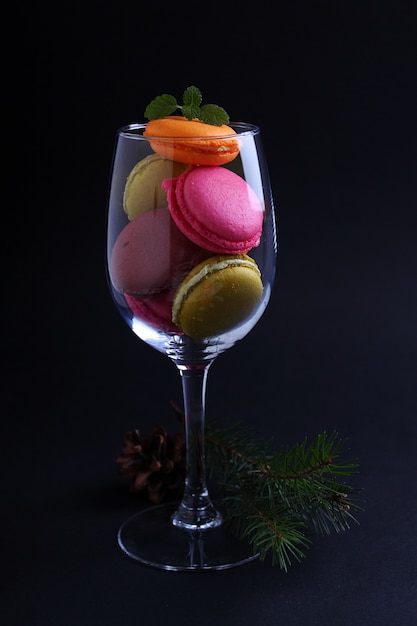 Bright multicolored macaroon cookies on a black table