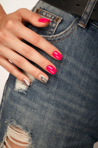 Bright neon manicure on female hands on the background of jeans Nail design Beauty hands