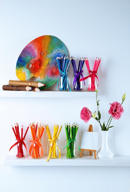 Photo bright pencils in glass jars on shelf