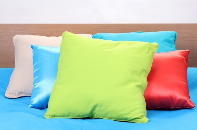 Bright pillows on bed on white space