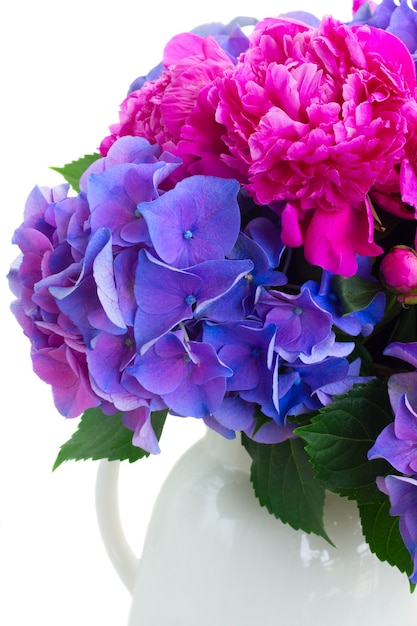 Bright pink peony and blue hortensia fresh flowers bouquet close up isolated on white