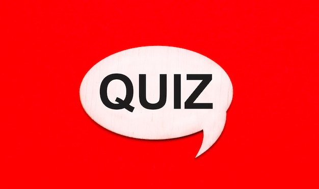 On a bright red background, a light wooden curly card with a dough QUIZ