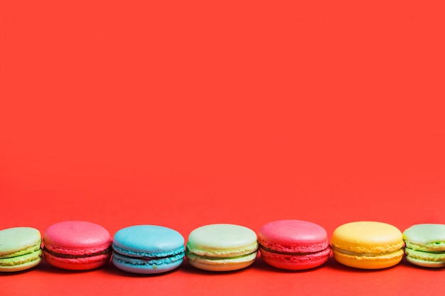 Bright red background for text with colorful yellow, green, blue, pink macaroons