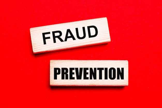 On a bright red background there are two light wooden blocks with the text FRAUD PREVENTION