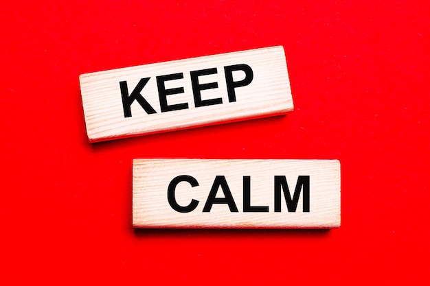 On a bright red background there are two light wooden blocks with the text KEEP CALM