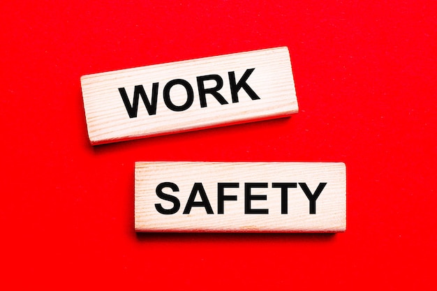 On a bright red background there are two light wooden blocks with the text WORK SAFETY