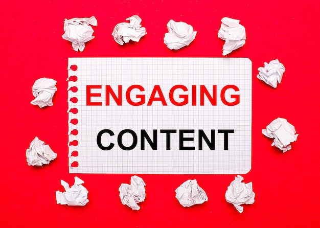 Photo on a bright red background white crumpled sheets of paper and a sheet of paper with the text engaging content