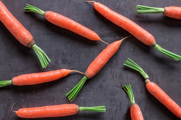 Bright ripe carrots with leaves on the table