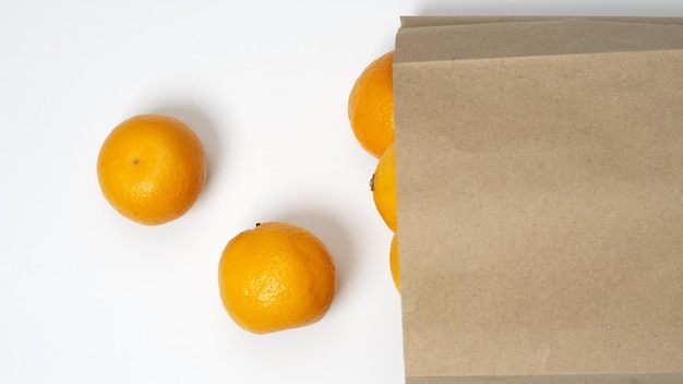 Bright ripe orange oranges in the package on a white background. View from above.