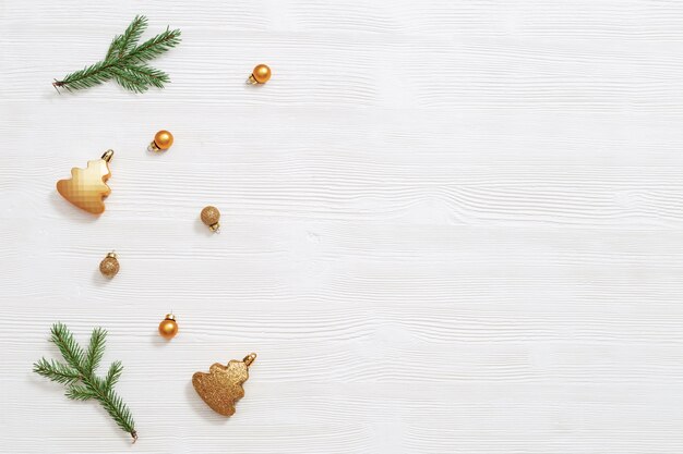 Bright shiny little Christmas balls gold colored with natural green fir tree branch, New Year decor