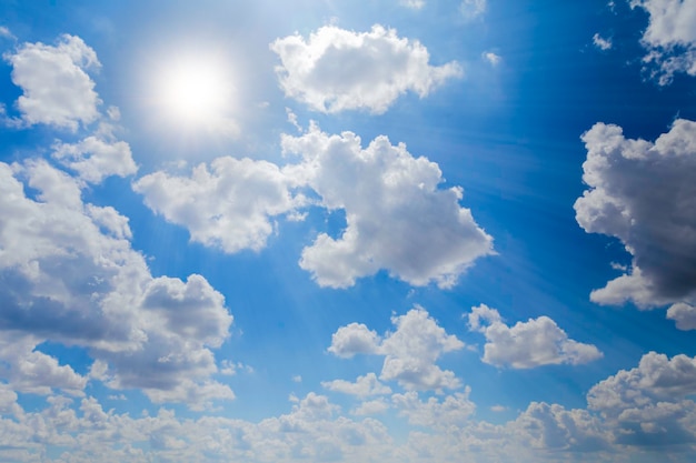 The bright sky was covered with white clouds illuminated by the sun's rays