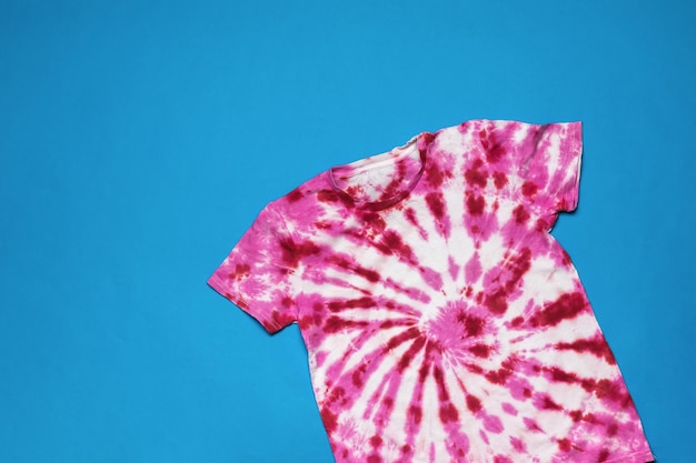 Bright stylish T-shirt on a bright blue background. Flat lay.