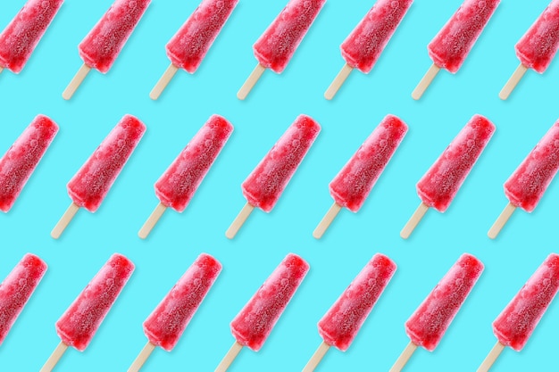 Photo bright summer pattern. red pink popsicles on an aqua blue background. top view.