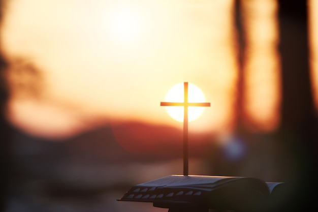 Bright sunlight, bible and holy jesus christ cross silhouette