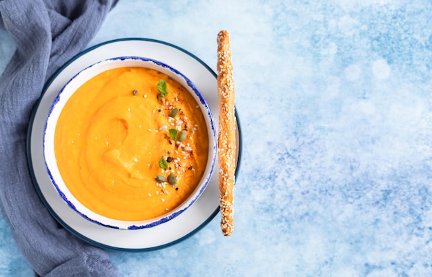 Bright vegetarian autumn pumpkin and carrot soup Comfort food fall and winter slow food concept