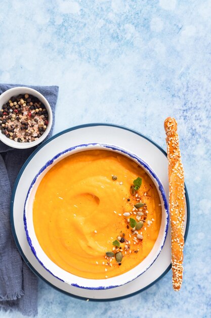 Bright vegetarian autumn pumpkin and carrot soup Comfort food fall and winter slow food concept