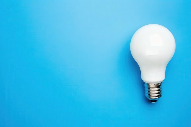 Photo a bright white light bulb rests on a blue backdrop symbolizing energy efficiency and sustainability in everyday life