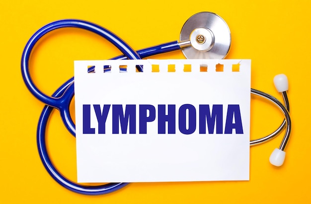 On a bright yellow background a blue stethoscope and a sheet of paper with the text LYMPHOMA Medical concept