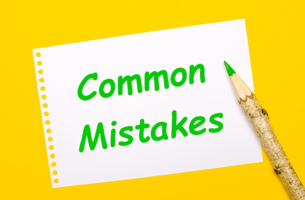 On a bright yellow background a large wooden pencil and a white sheet of paper with the text COMMON MISTAKES