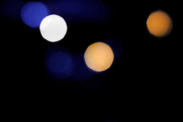 Bright yellow and blue blurry lights on a black background. Bokeh for post-processing photos, design.