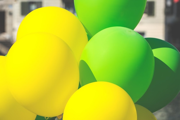 Bright yellow and green balloons on a city street