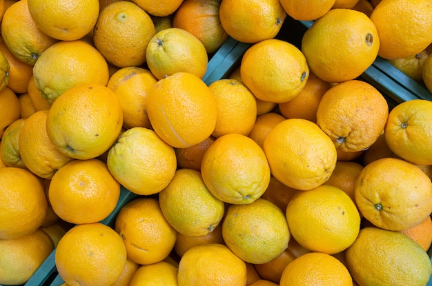 Bright yellow oranges in wooden boxes at farmer's market or grocery front view. May be used for . Top view.