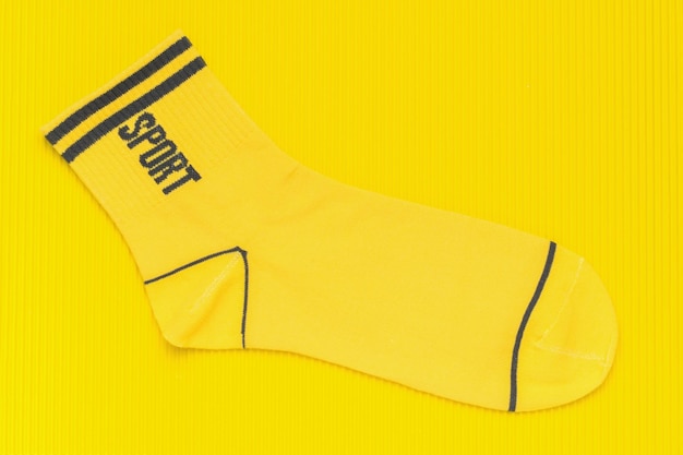 Bright yellow sock on a bright yellow abstract background Flat lay