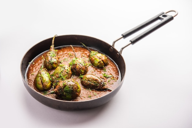 Brinjal curry also known as spicy baingan or eggplant masala, a popular main course recipe from India served in a bowl, karahi or pan